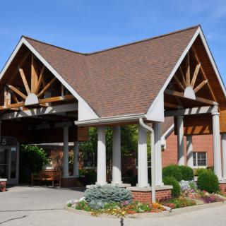 A building entrance with a triangular roof and supporting columns.