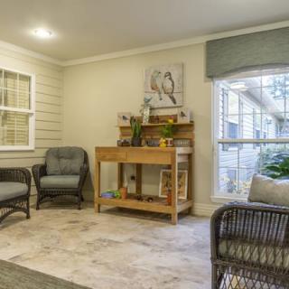 A cozy living room with comfortable seating, a wooden table, and decorative indoor plants.