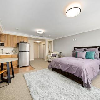 A modern studio apartment featuring a cozy bedroom and compact kitchen area.