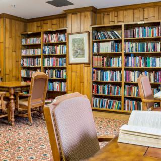 A cozy library reading room with shelves full of books and comfortable seating.