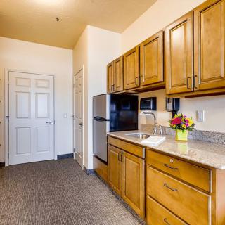 A small, modern kitchen with wooden cabinets and stainless steel appliances.