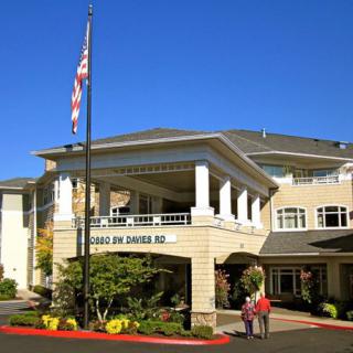 A well-maintained retirement home with a welcoming entrance and a flagpole.