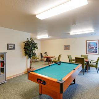 A cozy game room featuring a pool table and comfortable seating arrangements.