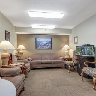 A cozy living room with comfortable seating, warm lighting, and a fish tank.