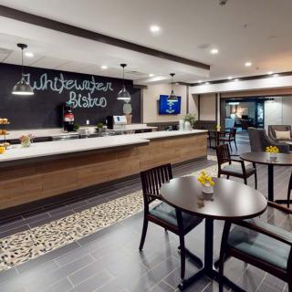 A modern cafe interior with a seating area and a chalkboard menu.