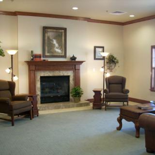 A cozy living room featuring a fireplace, comfortable chairs, and elegant decor.