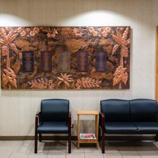 An empty waiting area with chairs and a small table, adorned with decorative wall art.