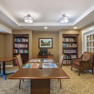 Cozy library room with bookshelves and a wooden table for reading.