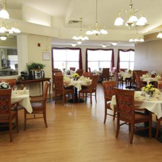 An elegant dining area with neatly arranged tables and chairs under soft lighting.