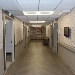 A view of a hospital corridor with doors leading to various rooms.