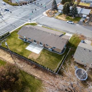 Aerial view of a house with a fenced yard located at the corner of an intersection.
