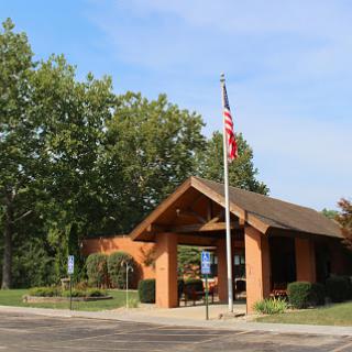 A welcoming entrance with a flag and greenery.
