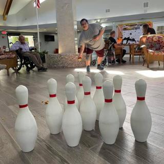 A group of people playing indoor bowling at a recreation center.