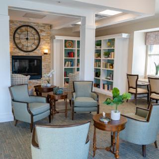 A cozy reading lounge featuring comfortable seating, bookshelves filled with books, and a warm atmosphere.