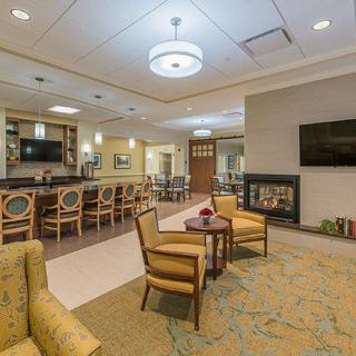 A modern lounge area with comfortable seating, a bar, and a fireplace.