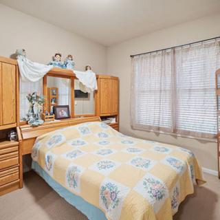 A cozy bedroom with wooden furniture and floral bedding.