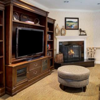 A cozy living room featuring a fireplace, entertainment center with a television, and comfortable seating.