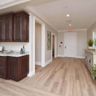 A modern hallway with wooden flooring, cabinets, and stylish decor.