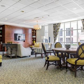 A spacious and well-lit lounge area with comfortable seating and large windows.