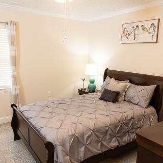 A cozy bedroom with a large bed, modern decor, and soft lighting.