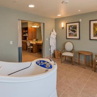 A luxurious spa-like bathroom featuring a modern bathtub, cozy seating area, and calming decor.