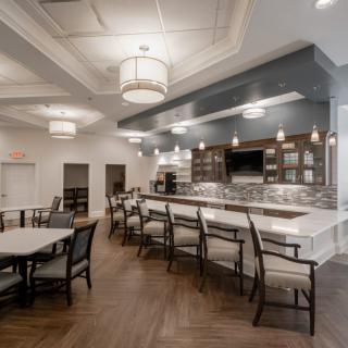A contemporary kitchen and dining area with bar seating, modern lighting fixtures, and elegant decor.