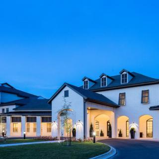 A beautifully lit building at dusk with a clear blue sky.