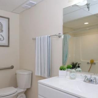 A modern, neatly arranged bathroom with a toilet, sink, and mirror.
