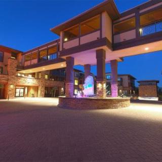 A modern building illuminated at night with architectural lighting and a clear sky backdrop.