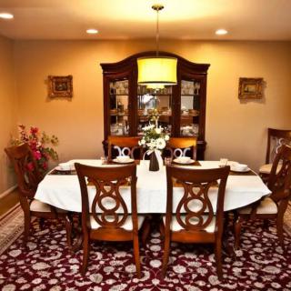 A cozy dining room with an elegantly set table and a china cabinet.