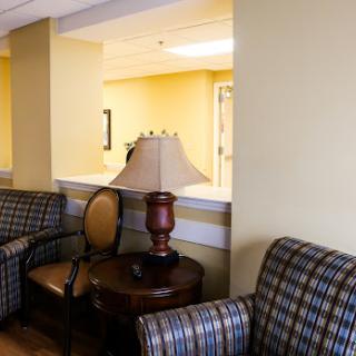 A cozy interior space featuring patterned chairs, a lamp, and warm yellow walls.