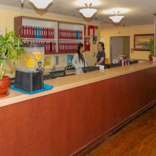 A reception desk area in an office with two people interacting.