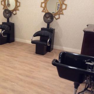 Interior of a hair salon with styling chairs, mirrors, and hair dryers.