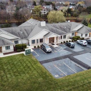 Aerial view of a single-story building with a parking lot and surrounding grass.