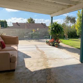 A cozy patio with comfortable seating overlooks a sunny garden.