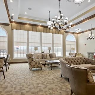 A luxurious living room with elegant sofas, chandeliers, and large windows.