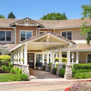A two-story residential building with a landscaped entrance.