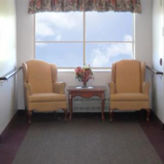 A cozy seating area with two chairs and a small table by a window.