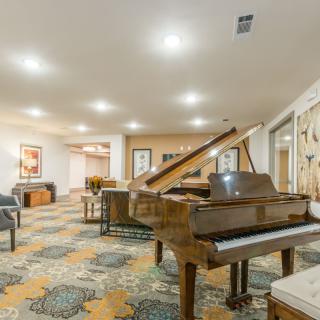 A cozy lounge featuring a grand piano and comfortable seating arrangements.