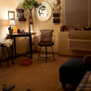 A cozy and inviting room setup featuring a desk, a chair, and warm lighting.