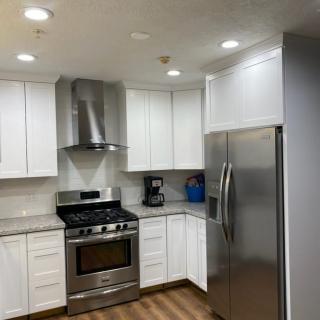 A modern kitchen with stainless steel appliances and white cabinets.