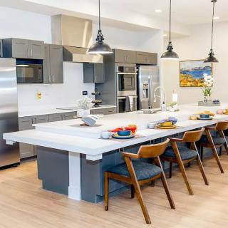 A modern kitchen featuring a large island with seating and sleek stainless steel appliances.