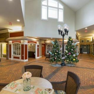 A cozy indoor lobby decorated with Christmas trees and seating arrangements.