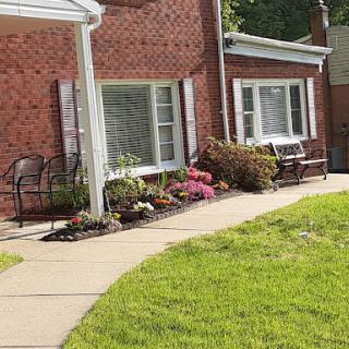 A charming house with a well-maintained garden and a winding walkway.