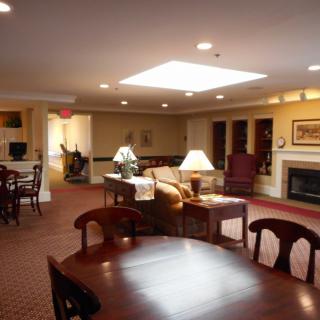 A cozy living room featuring comfortable seating, a fireplace, and elegant lighting.