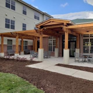 A modern building with a wooden patio and outdoor seating area.