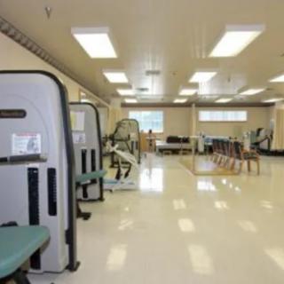A spacious rehabilitation center equipped with various exercise machines and therapy areas.