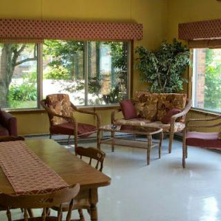 A cozy living room with comfortable seating, natural light flowing in through large windows, and a touch of greenery.