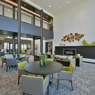 A modern lobby with stylish furniture and a fireplace.