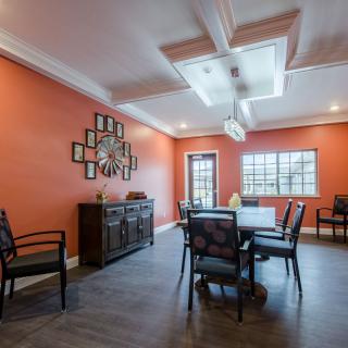 A modern dining room with orange walls, featuring a stylish ceiling design and contemporary furniture.